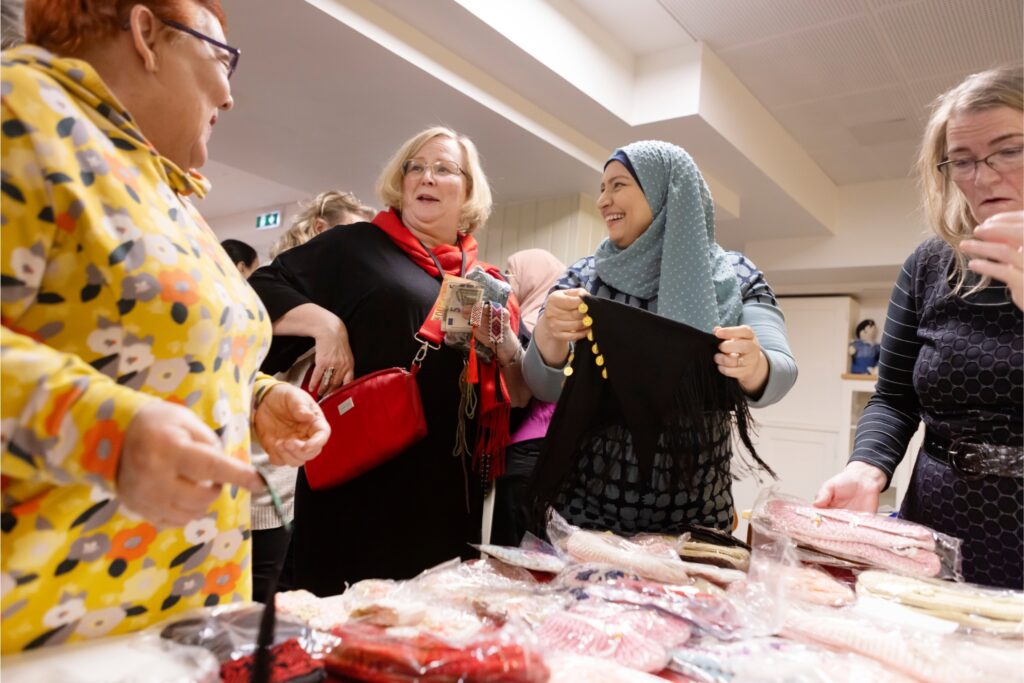 Sirpa Tiainen (vas.), Tarja Rintakoski, Housana Alfashtaki ja Kirsti Korpisalo tutkivat myynnissä olevia käsitöitä.